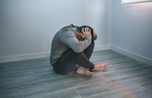 man sitting in the corner frustrated